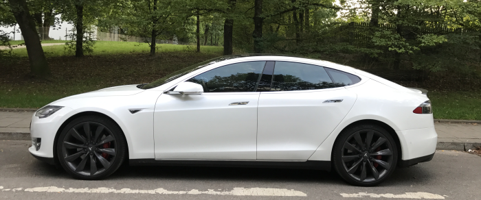Ein weißes Elektroauto, als solches nicht zu erkennen aber fast nicht hörbar auf der Straße
