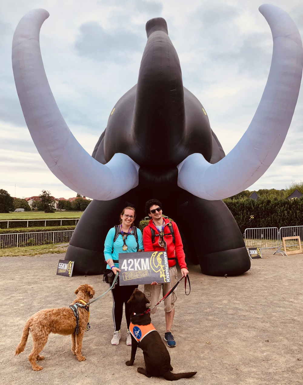 Meine Freundin, die Hunde und ich vor dem Mammutmarsch-Mammut, mit Medaillen und 42km Tafel
