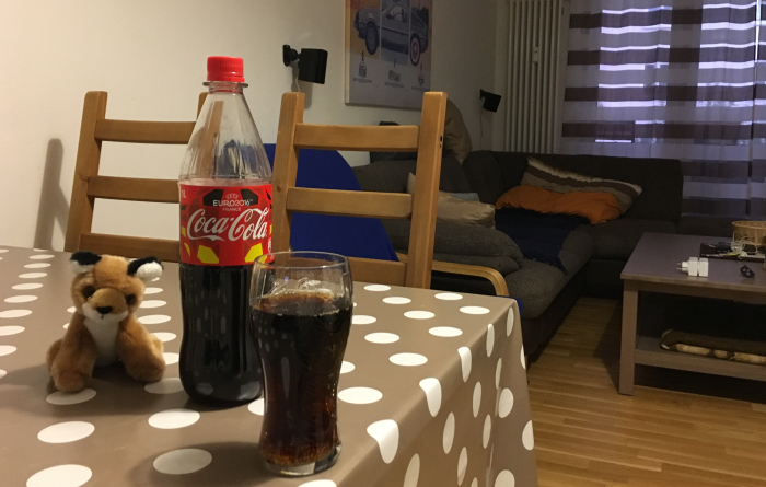 Ein Colaglas am Tischrand