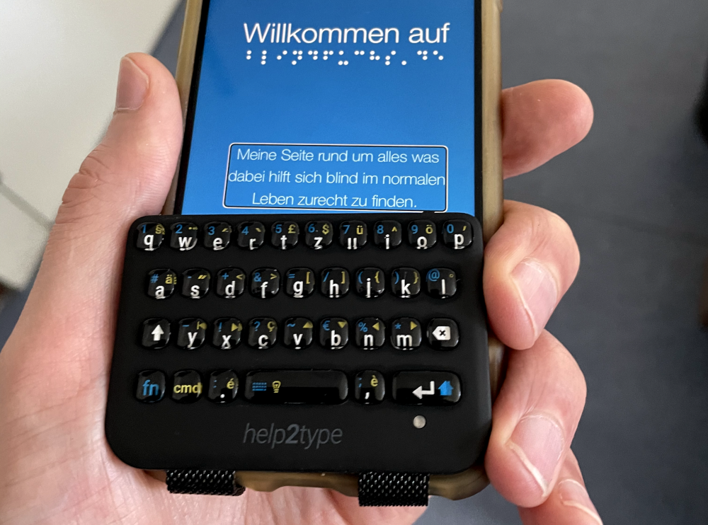 Die help2type passt perfekt auf mein iPhone. Im unteren Bereich sind die Bänder zum sicheren Wegklappen zu sehen